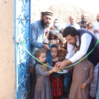Children and adults cut an inauguration ribbon