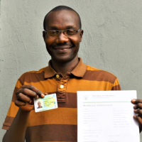 Mupenzi proudly holds his new ID card as well as marriage certificate issued by the Rwandan Government