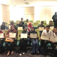 Students hold up their diplomat to the camera