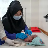 Student midwife Masoma performs checks on a newborn under supervision at the hospital.