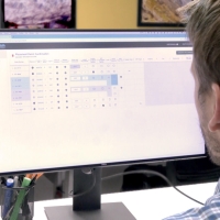 A person looking at a computer screen with the GroMatch tool open. On the screen, there is a table with some boxes checked