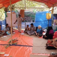 People sitting in a circle in a tent