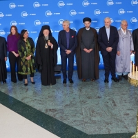 A group photo from the candle lighting ceremony at the Global Refugee Forum 2023 - religious leaders and the High Commissioner stand together in a line