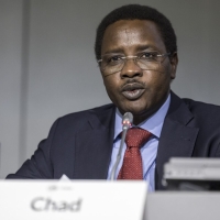 A man in a panel, speaking, with the nameplate of Chad in front of him