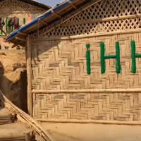 House made out of bamboo in a camp setting.