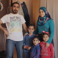 Family smiling and looking at the camera.