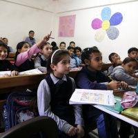 Kids in a classroom seated.