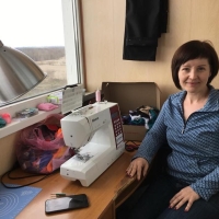 Woman next to a sowing machine.