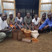 A group of people show cooking pots.