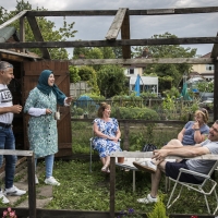 A group of people sitting in a garden smiling