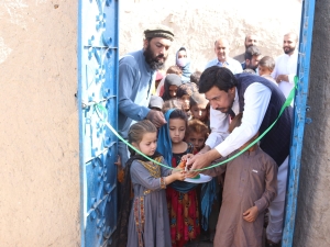 Children and adults cut an inauguration ribbon