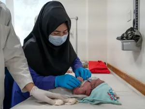 Student midwife Masoma performs checks on a newborn under supervision at the hospital.