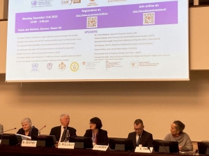 Photo of the panel - six speakers sit in a row with a presentation on a screen behind them