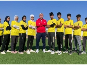 Group photo showing youths in sports clothes standing in a row, their arms folded.