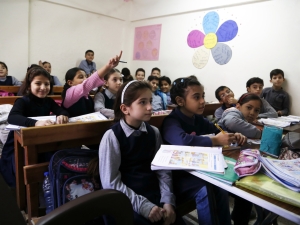Kids in a classroom seated.