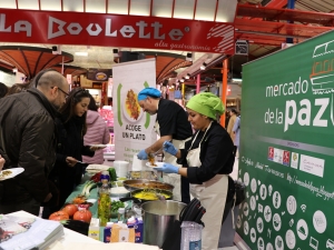 People being served food at a food market.