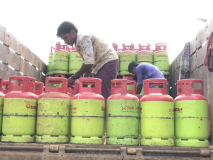 Man in middle of gas containers on top of a truck.
