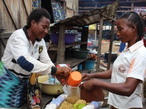 Ortense serving a customer at her market stall