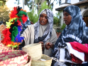 Two ladies shop at a market stall