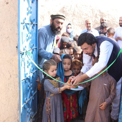 Children and adults cut an inauguration ribbon