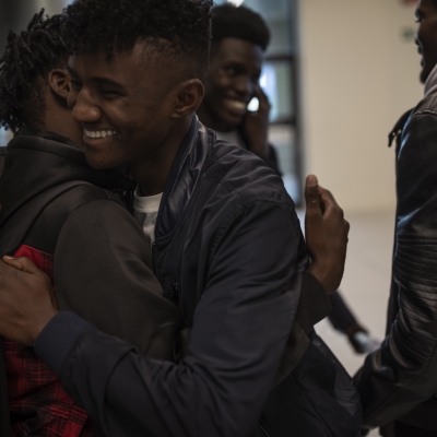 Men smiling and hugging