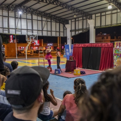 Two clowns performing in the middle of a sports hall with the audience in the foreground