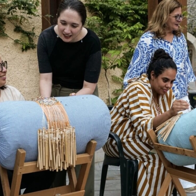 Women making lace demonstrate their craft to onlookers