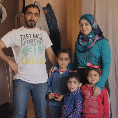 Family smiling and looking at the camera.