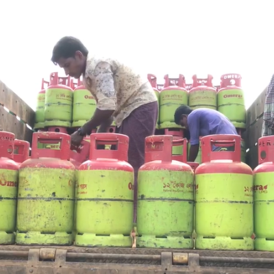 Man in middle of gas containers on top of a truck.