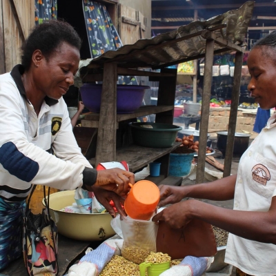 Ortense serving a customer at her market stall