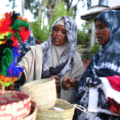 Two ladies shop at a market stall
