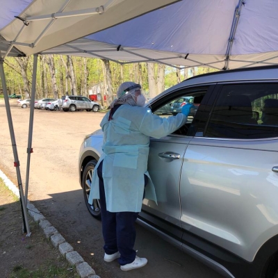Iraqi refugee helps at a drive-thru coronavirus testing centre