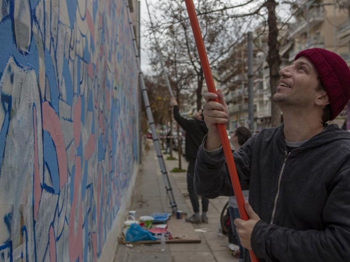 Greek artist Sotiris Fokeas and the Collectif Mazi refugee art group paint a mural on the walls of the Theagenio Cancer Hospital in Thessaloniki.