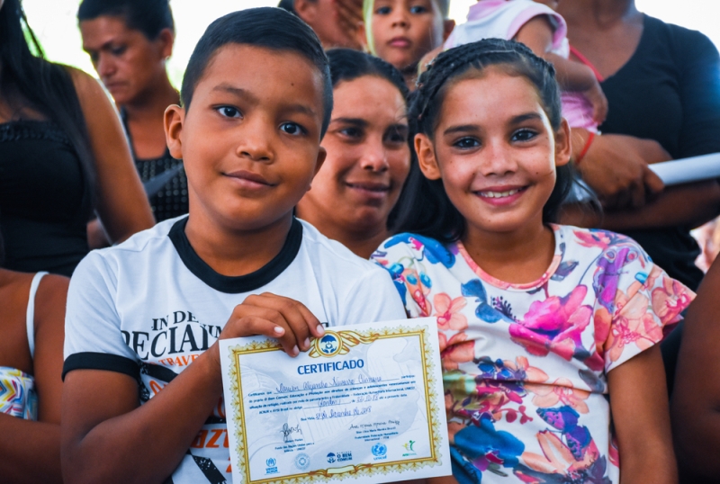 Children holding a certificate for participating in the project.