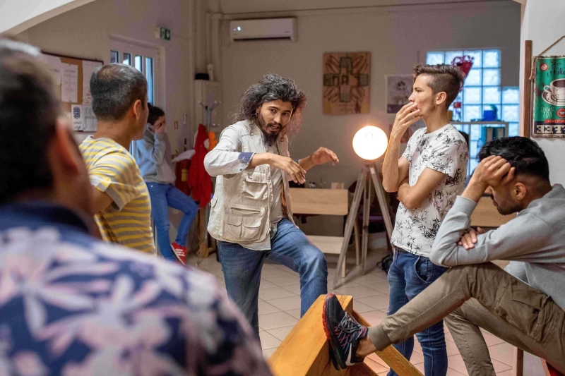 A group of people are in a circle rehearsing