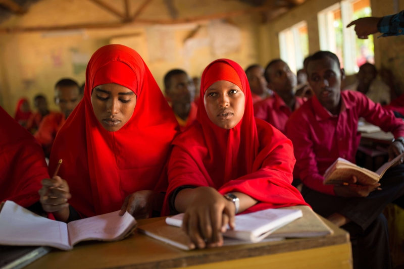 Two girls sitting at their desk in a classroom studying