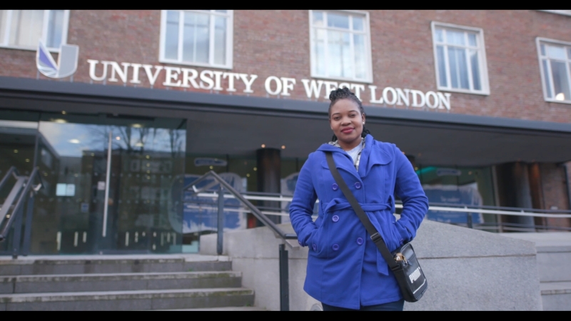 A woman stands in front of a building that says "University of West London"