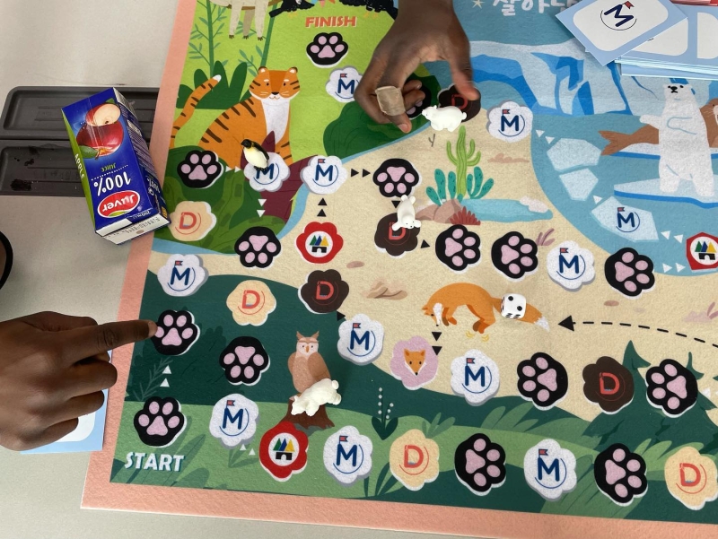 Photo of the board game - cartoon images of various animals (foxes, tigers, owls, polar bears) and pawprints marking the path through the game