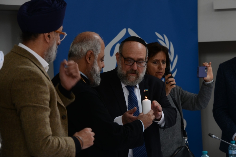 Religious leaders give one another lit candles