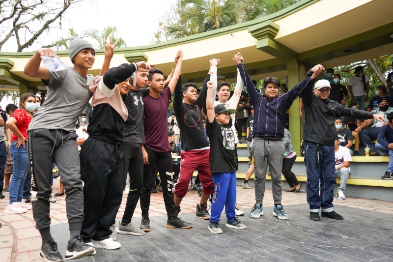 A group of children hold hands and cheer