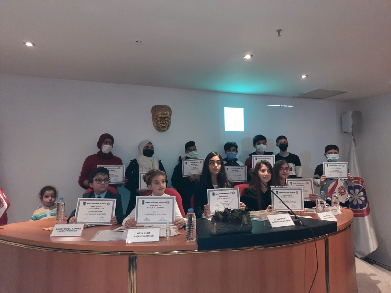 Children show their diplomas to the camera