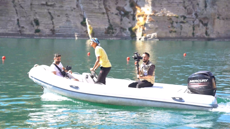Three people on a boat, some are holding cameras
