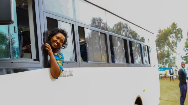 A woman leaning out of a bus window, smiling