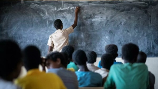 A Malian refugee student plays the role of teacher at a school in Goudoubo camp