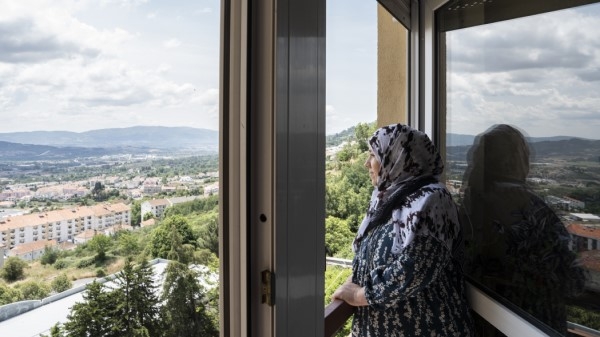 Woman looking out of a window over the city