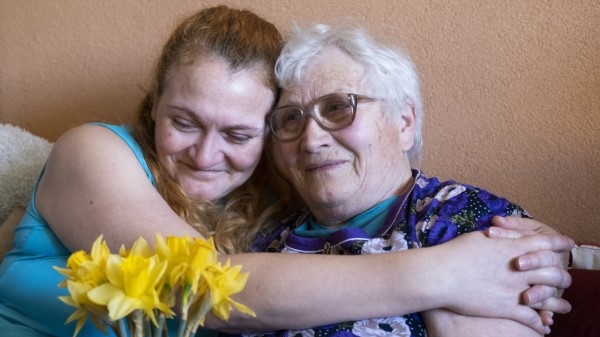 An older and younger woman cuddling