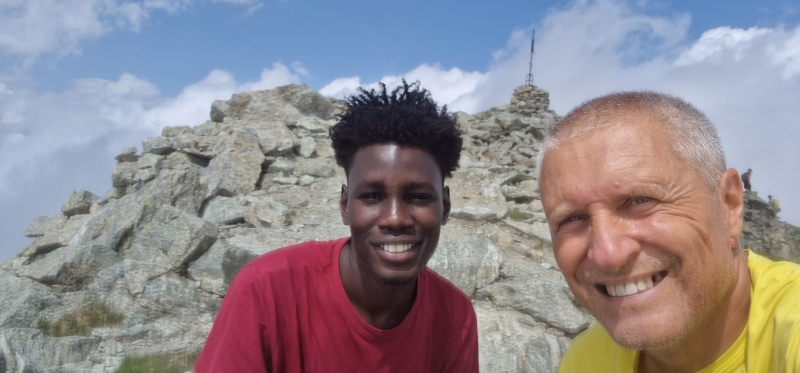 One younger man and an older one smile to the camera