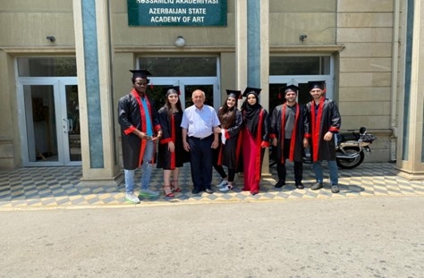 Graduates posing in front of a university