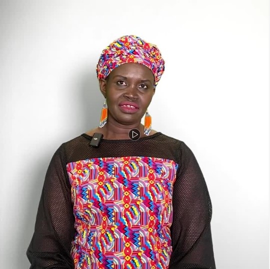 Angelina Nyajima standing with a white background behind them, facing the camera