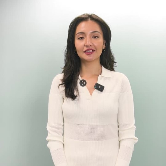 Sara Wahedi standing with a white background behind them, facing the camera
